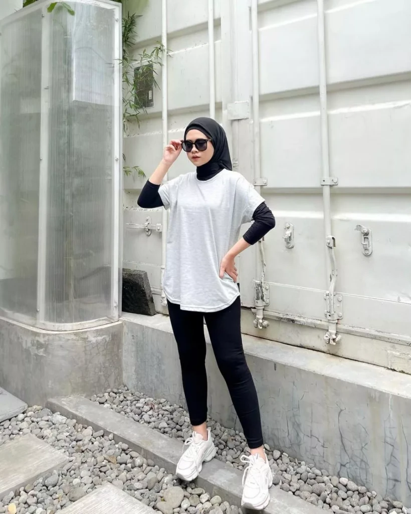 jilbab hitam dan manset hitam lalu memadukannya dengan kaos oversized berwarna putih